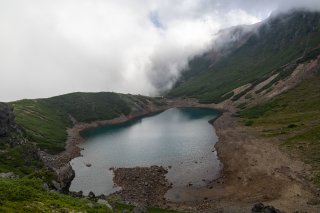 雲に覆われる山の池